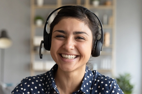 student wearing headphones with a huge smile