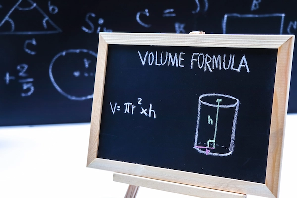 a chalkboard with a Volume Formula written out