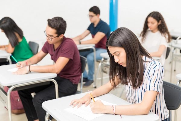 students sitting at their desks in a classroom taking a test